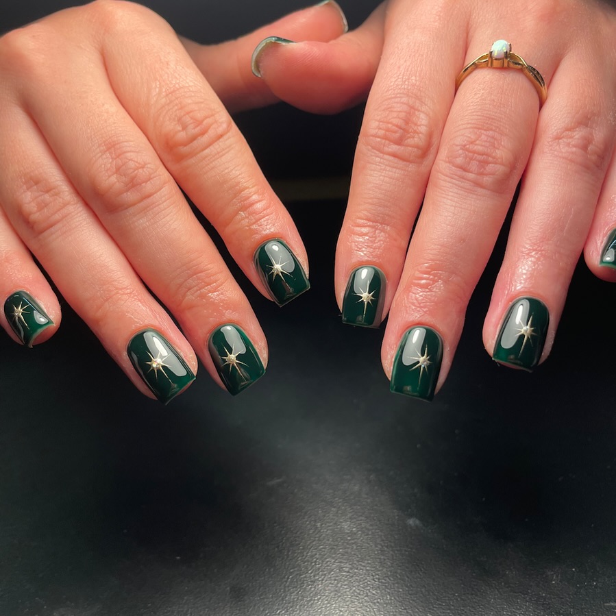 Μανικιούρ με μικρά χρυσά αστέρια - Twinkling star nails σε σκούρα βάση που μαγνητίζουν το βλέμμα